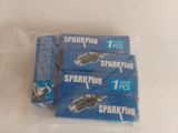four packs of spark plugs sitting on top of a white table