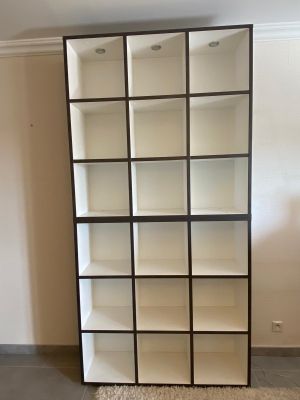 a tall bookcase in the corner of a room