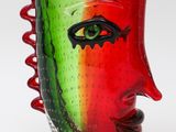 a glass vase with a face painted on it