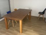 a wooden table in the middle of a room with two chairs