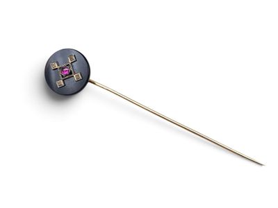 a close up of a metal stick with a pink stone on it