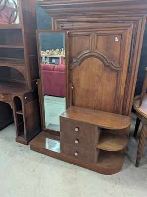 une photo d'un ensemble de meubles en bois avec un miroir