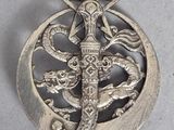 une image représentant une broche en argent surmontée d'une étoile