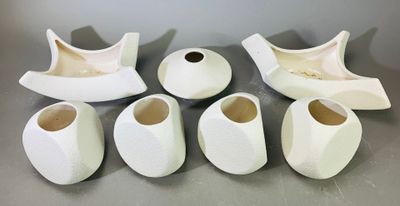 cinq vases blancs posés les uns à côté des autres sur une table
