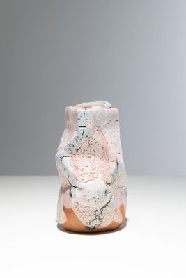 un vase blanc orné d'un motif rose et bleu
