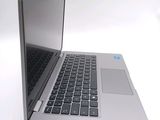 a silver laptop with a black keyboard on a white surface