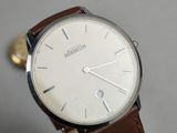a close up of a wrist watch with a brown leather strap