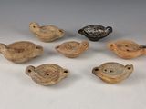 six pièces de poterie posées sur une table, à côté d'un bol