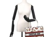 the mannequin is holding a purse on a mannequin stand