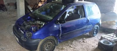 une petite voiture bleue avec un capot abîmé dans un garage