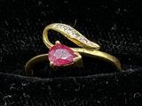 an image of a gold ring with a heart shaped ruby stone