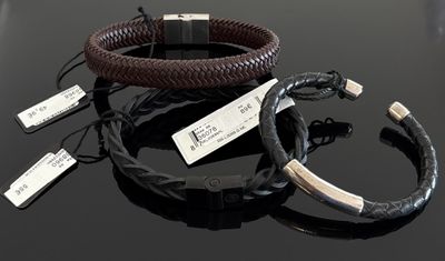 deux bracelets en cuir posés sur une table, accompagnés d'étiquettes