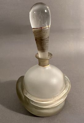une bouteille en verre d'où sort un bâton en bois