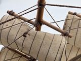 a small wooden model of a sail boat on a table