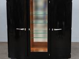 a black cabinet with glass shelves and a glass door
