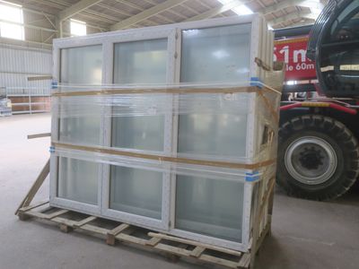 une grande pile de blocs de verre posée sur une palette dans un entrepôt
