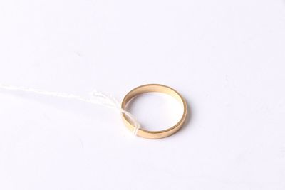 a close up of a gold ring on a string on a white surface