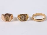 three gold rings with diamonds on them on a white surface