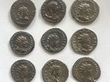 six ancient roman coins are arranged in a row on a white surface