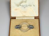 an image of a silver and glass broochle in a case