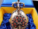 a silver pocket watch in a blue box on a blue cloth
