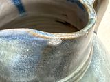 a close up of a vase with a handle on a table