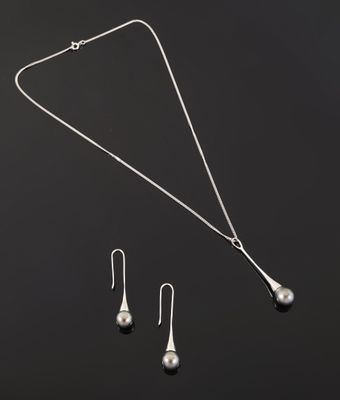 un ensemble composé d'un collier et de boucles d'oreilles en argent sur fond noir