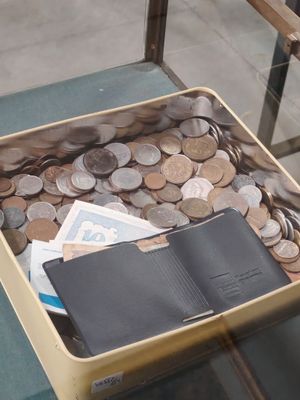 une valise remplie de pièces de monnaie et un passeport posés sur une table