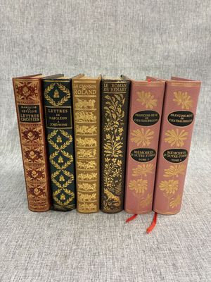 quatre livres sont alignés les uns à côté des autres sur une surface grise