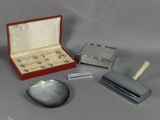 une petite boîte contenant un miroir, un couteau et d'autres objets, posée sur une table