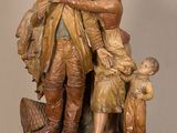 statue représentant un homme et deux enfants, placée à côté d'une statue représentant un homme et deux enfants