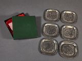 six silver trays and a green box on a table