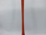 an orange vase sitting on top of a table next to a white wall