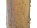 a glass vase that has a flower etched on it