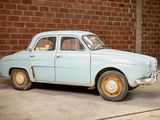a small blue car parked in front of a brick wall