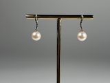 une paire de boucles d'oreilles ornées de perles suspendues à un support