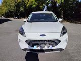 the front end of a white car parked on the side of the road