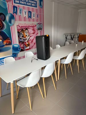 des tables et des chaises dans une pièce où est accrochée une grande affiche au mur
