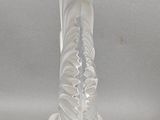 un vase en verre transparent surmonté d'un oiseau
