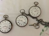 three different types of pocket watches sitting on a table