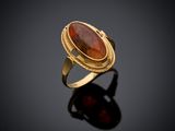 a gold ring with a red stone in the center