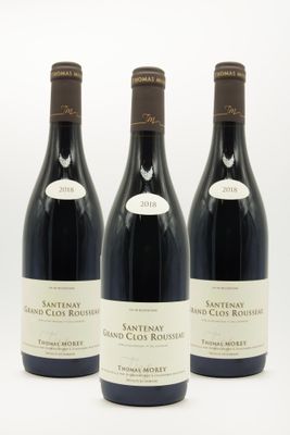 trois bouteilles de vin sont alignées sur une surface blanche