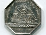 une pièce d'argent sur laquelle est représenté un bateau