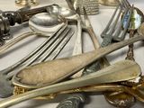 many silver spoons and forks on the table