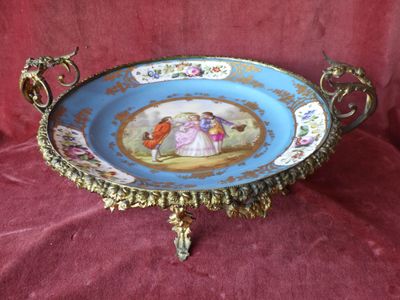 une assiette bleue et dorée sur laquelle figure une image