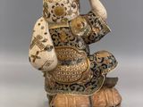 an image of a figurine of a man sitting on top of a wooden barrel