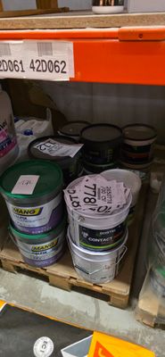 de nombreux seaux de peinture sur les étagères du magasin