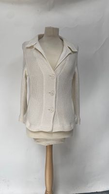 beige sweater on a mannequin stand against a white backdrop