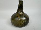 un vase vert posé sur une surface blanche