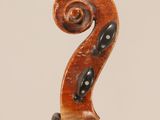 an antique violin with a scroll on the back of it